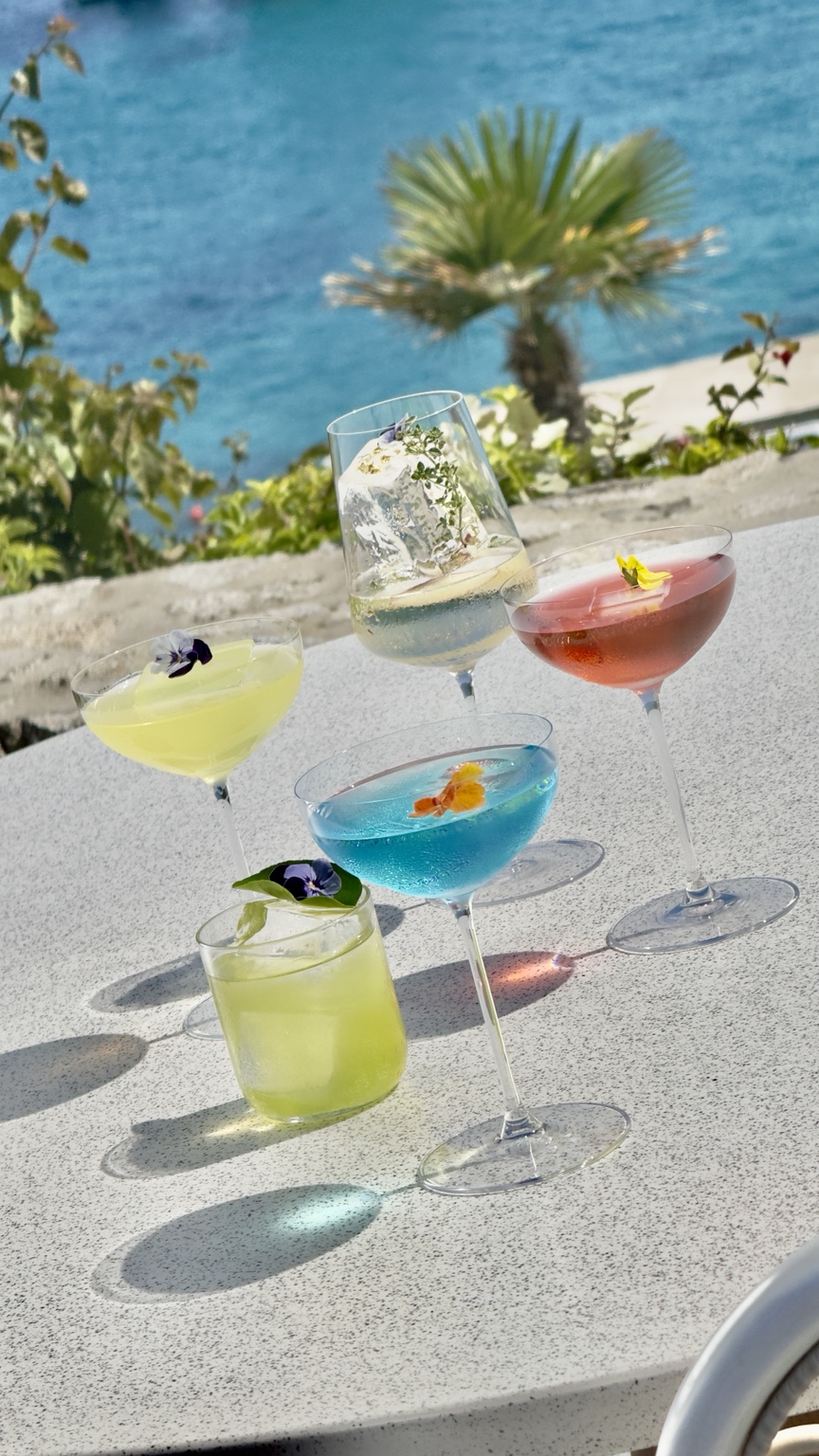 A collection of colourful cocktails overlooking the sea in Mykonos
